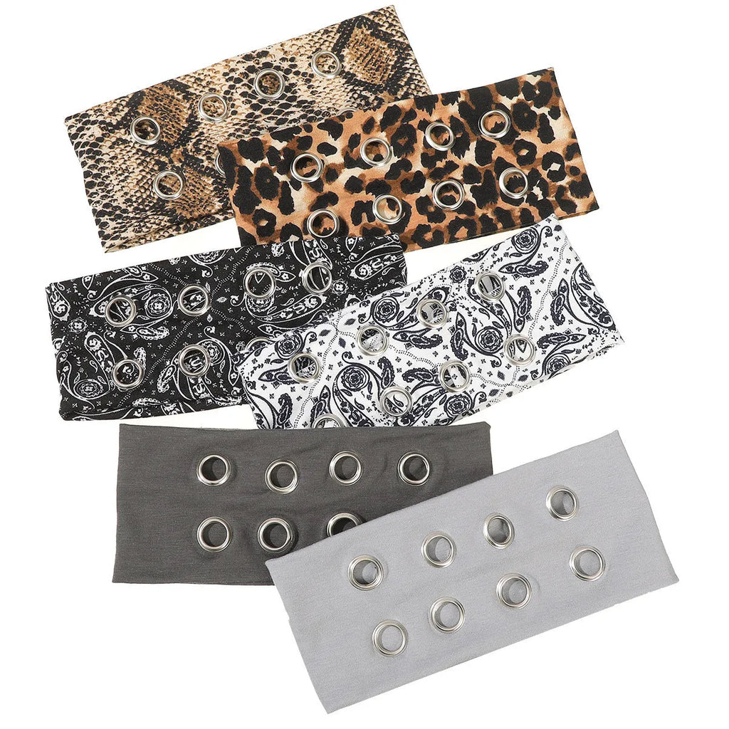 A black polyester exercise hair band with a hollow metal decorative centrepiece.