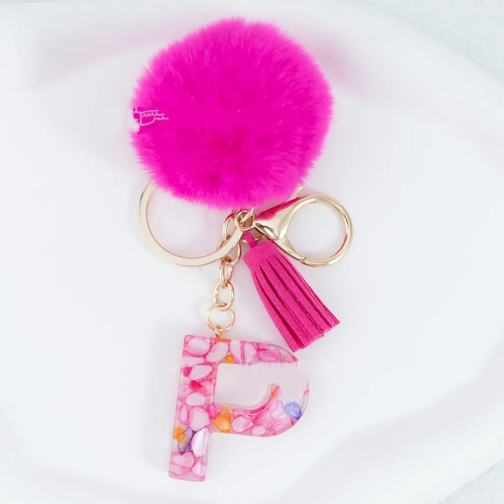 Rose red stone keychain with English letter B, fur ball and tassel on a white background