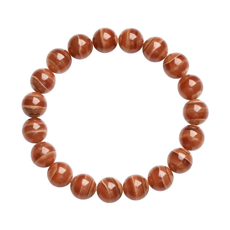 Natural old mine rhodochrosite bracelet with geometric beads and Ruyi symbols on a wrist.