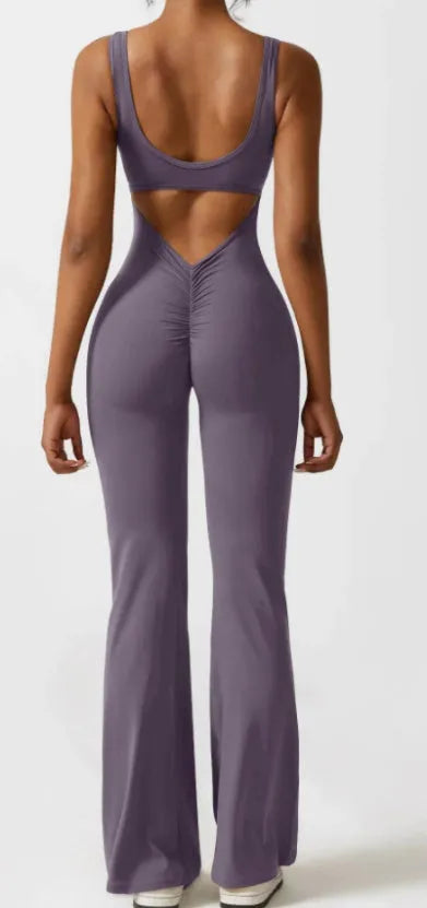 Black seamless women's yoga bodysuit jumpsuit with built-in chest pad, shown on model.