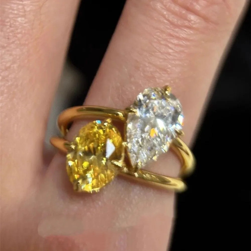 Geometric open copper ring with a water drop double Sheng stone zircon centrepiece.