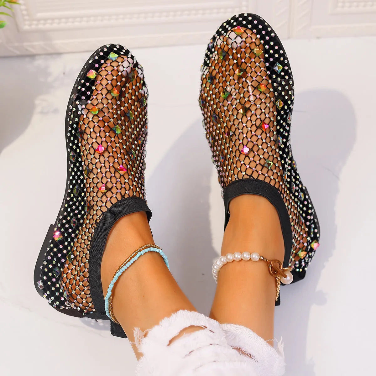 Women's flat sandals with mesh upper, colourful rhinestone design, and round toe on a rubber sole.