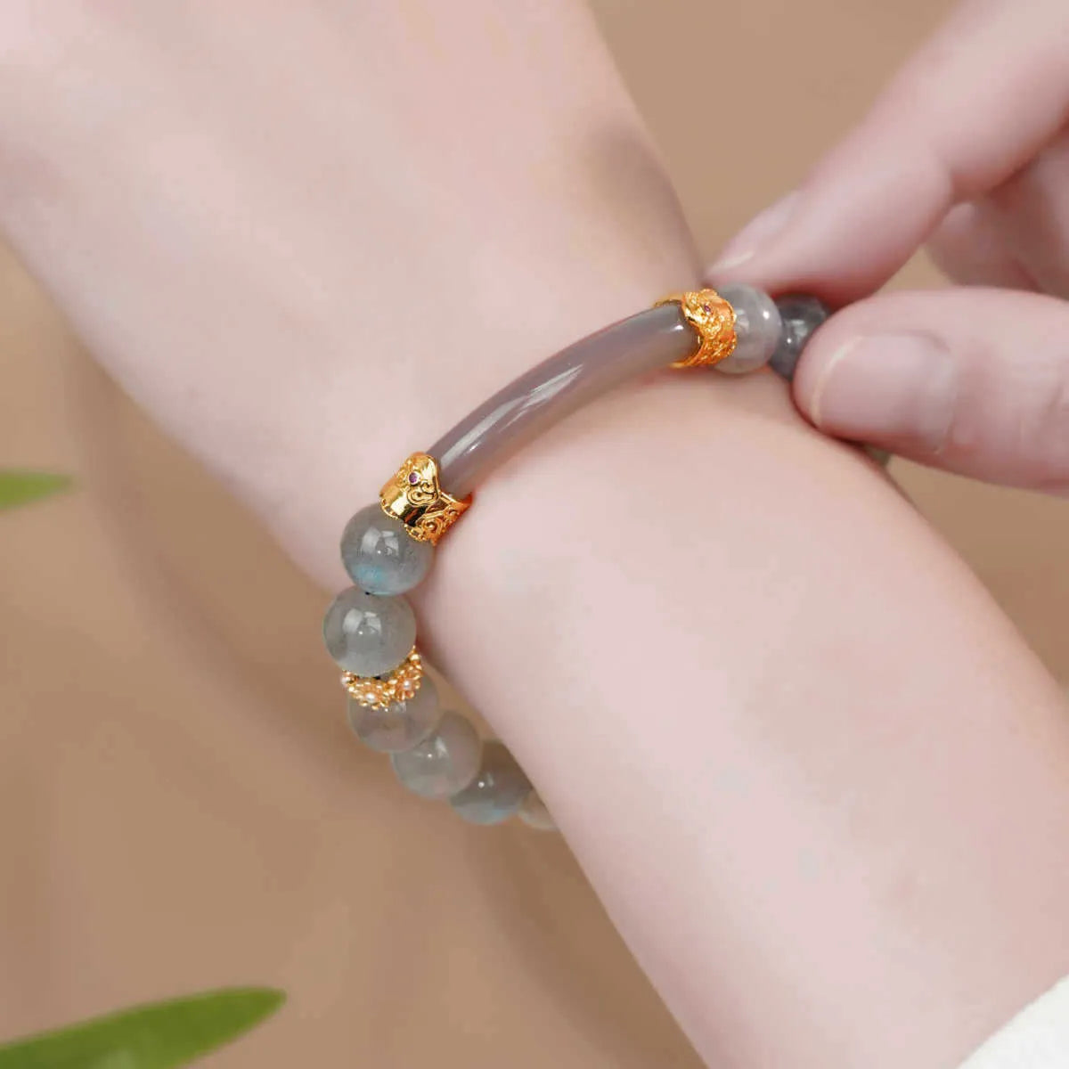 Grey moonstone bracelet with 8mm round beads on a wrist.