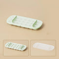 Yellow high-capacity ice cube tray with leverage handle and stored ice shovel.