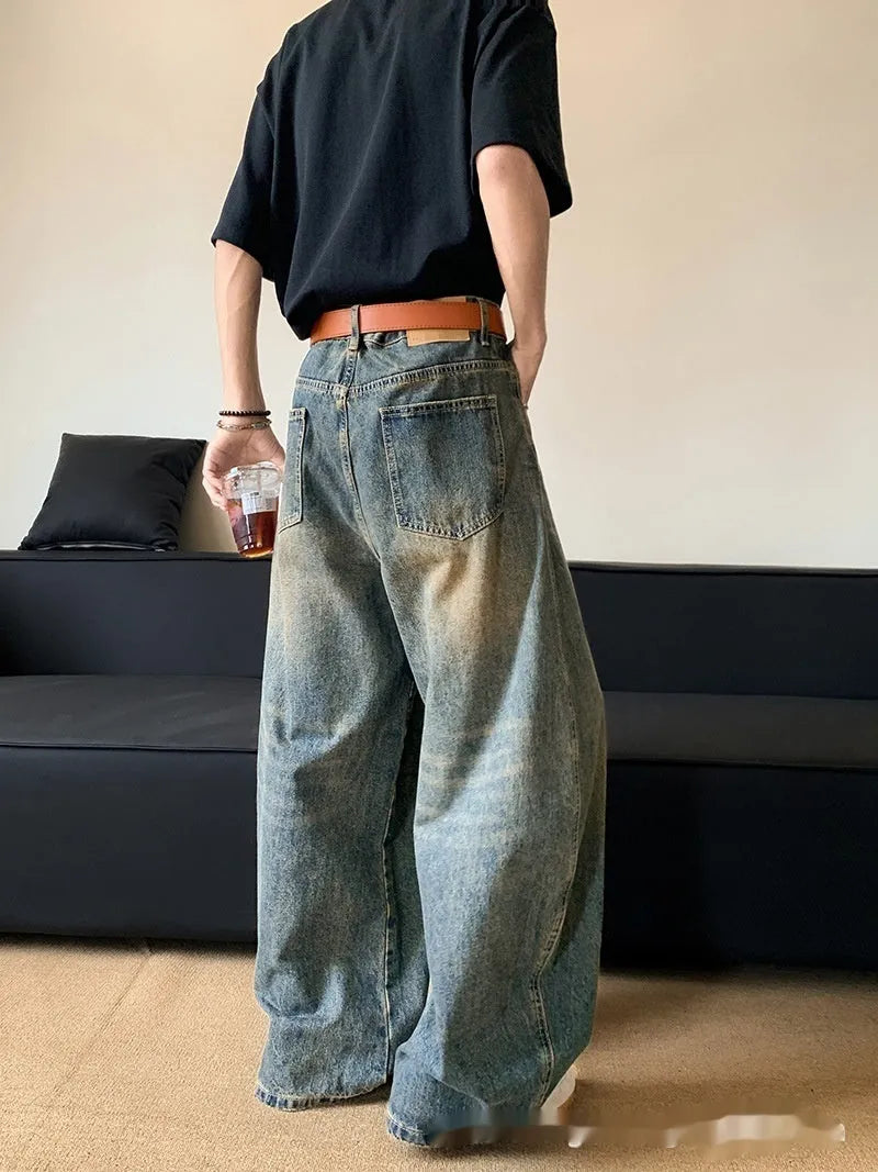 Men's retro blue distressed denim jeans with slim fit wide leg design showing machete wash detailing