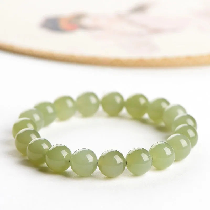 Unisex Hetian jade ball bead bracelet in ice clear colours, showing polished spherical beads on a string.