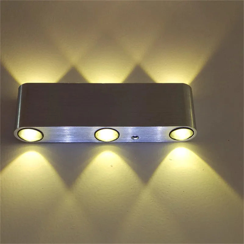 Silver aluminium rectangular LED wall lamp showing seven colour lighting options on bedroom wall