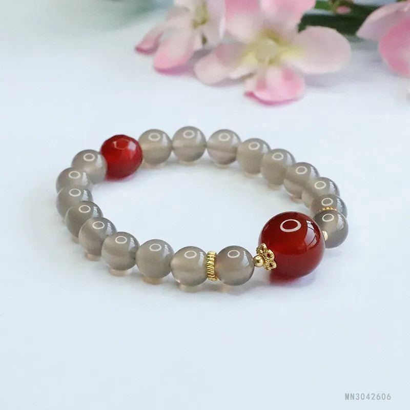 Smoky purple and red agate bracelet with 8mm geometric beads on a wrist.