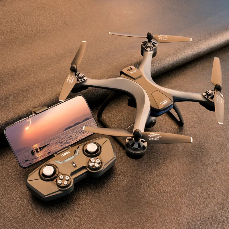 Black plastic quadrocopter drone with four propellers, a camera on front, and a remote control handle.