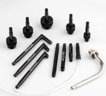 Thirteen-piece automatic transmission oil refuelling kit with pump tool and adapters on a workbench.
