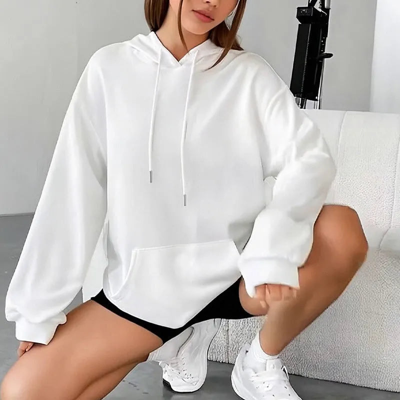 Women's loose grey drawstring hoodie with front pocket, shown in a casual setting.