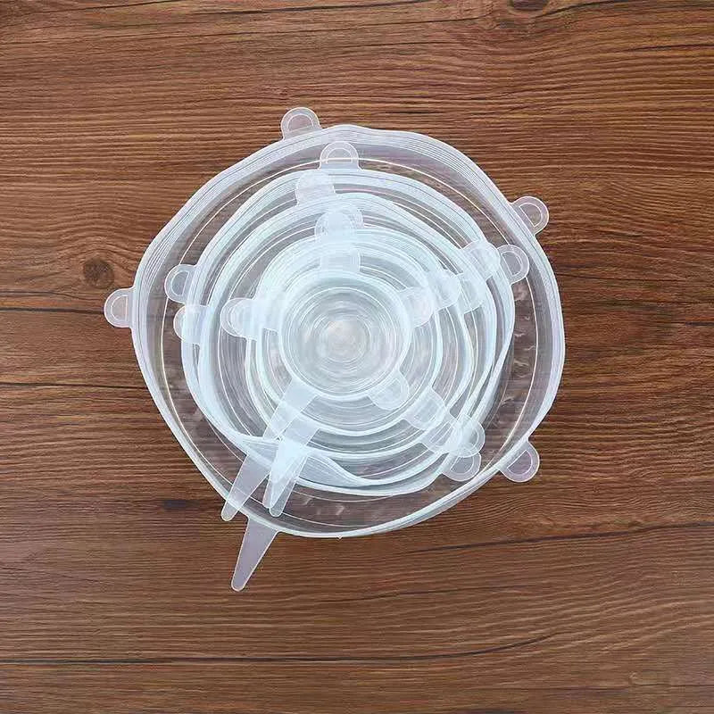 Set of six colourful silicone stretch lids in different sizes arranged on a kitchen counter.