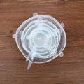 Set of six colourful silicone stretch lids in different sizes arranged on a kitchen counter.