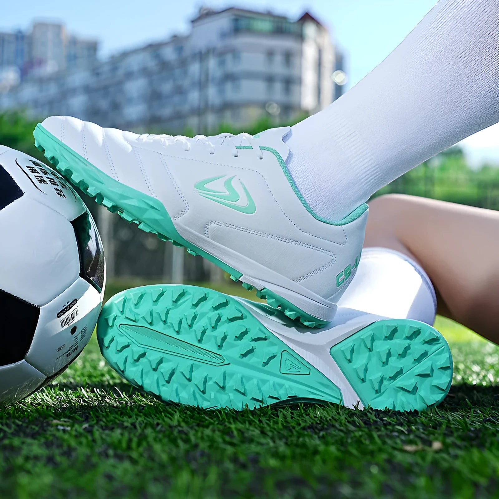 Low-top turf soccer shoes in black and white broken nails colour with synthetic leather upper