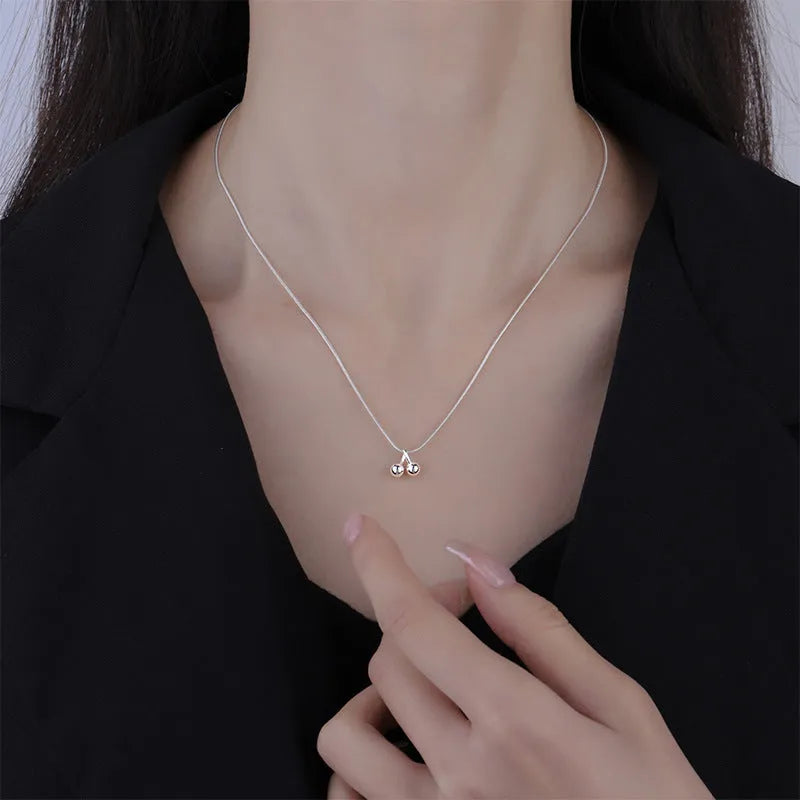 Silver cherry necklace for women with adjustable snake bone chain on a white background.