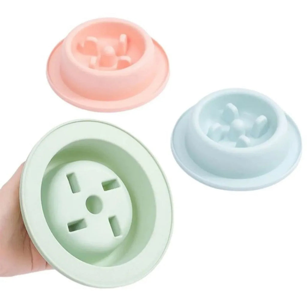 Blue pet slow feeder bowl with raised obstacles on a kitchen floor.