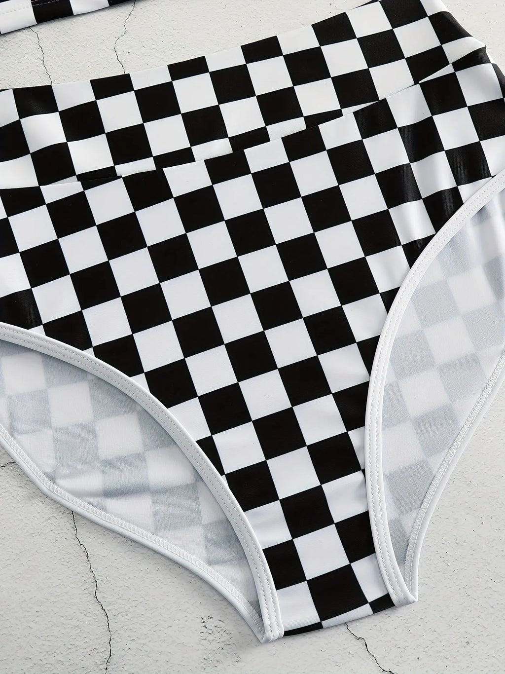 Women's black and white plaid racing one-piece swimsuit with backless design and adjustable suspender straps.