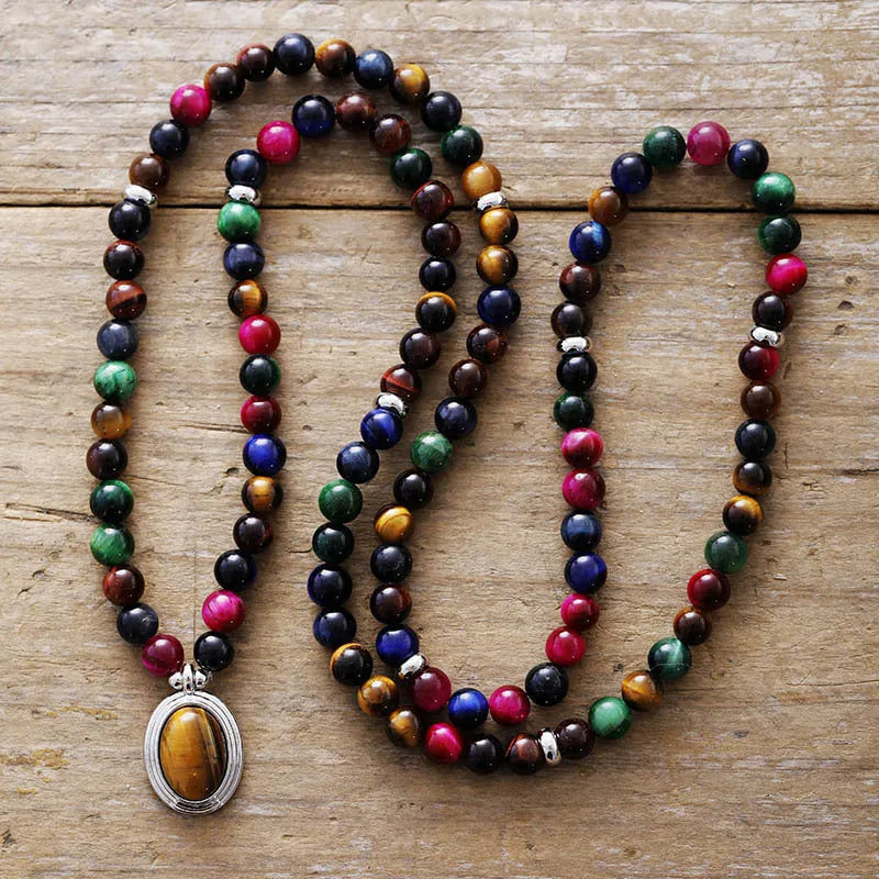 Close-up of a tiger-eye stone bead necklace with 108 gem-inlaid pendants showing heart, crown, and infinite symbols.