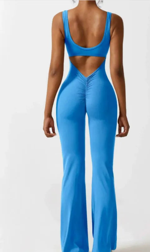 Black seamless women's yoga bodysuit jumpsuit with built-in chest pad, shown on model.