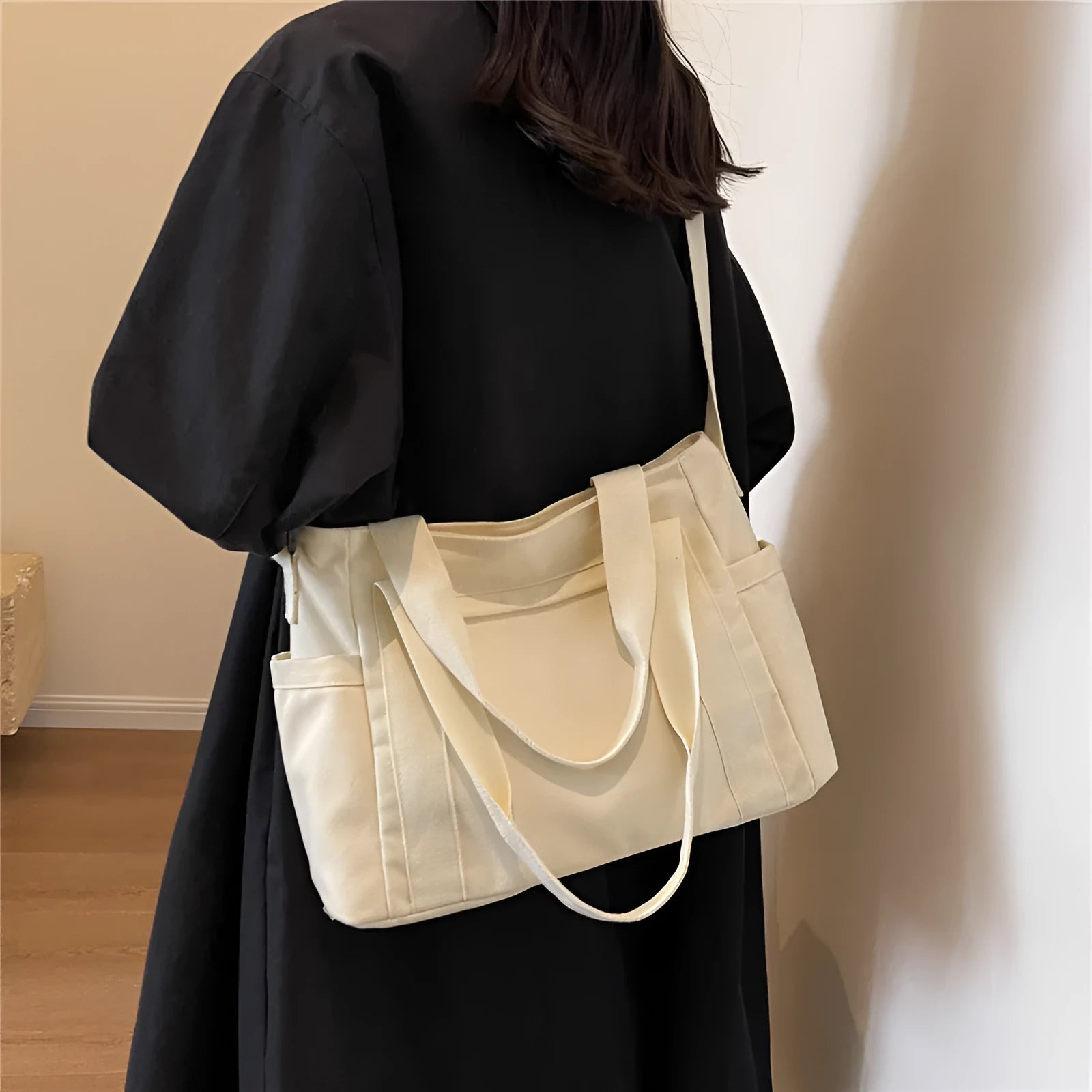 Polyester shoulder tote bag in solid colour with external sandwich pocket and internal phone pouch.