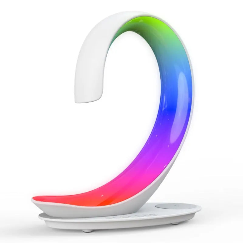 White swan sculpture desk lamp with integrated wireless phone charger and Bluetooth speaker emitting colourful light.