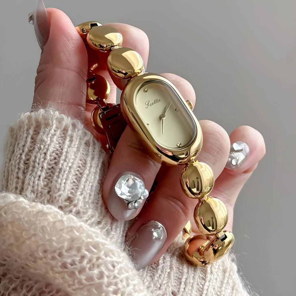Women's oval gold tone watch with bracelet and 9mm case thickness
