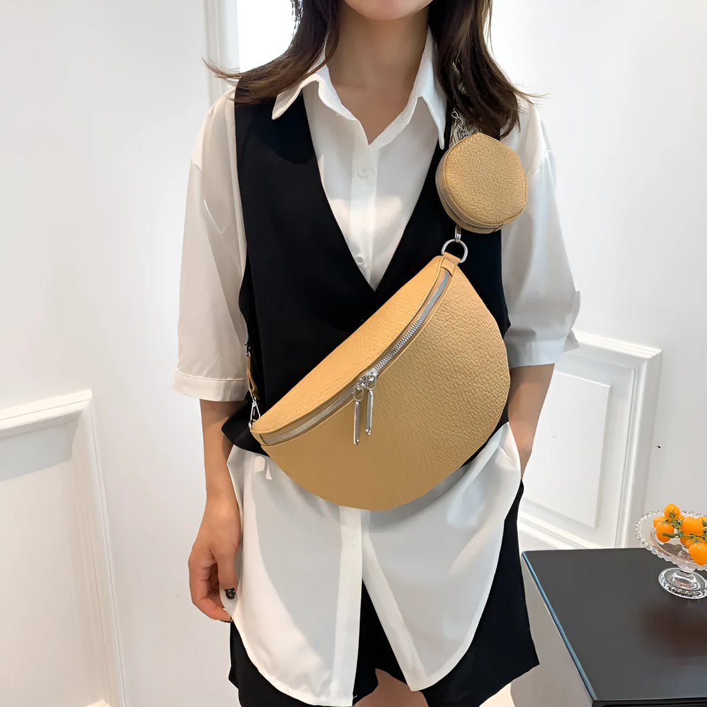 Solid colour women's crossbody bag with saddle lock detail, shown in a horizontal square clamshell shape.
