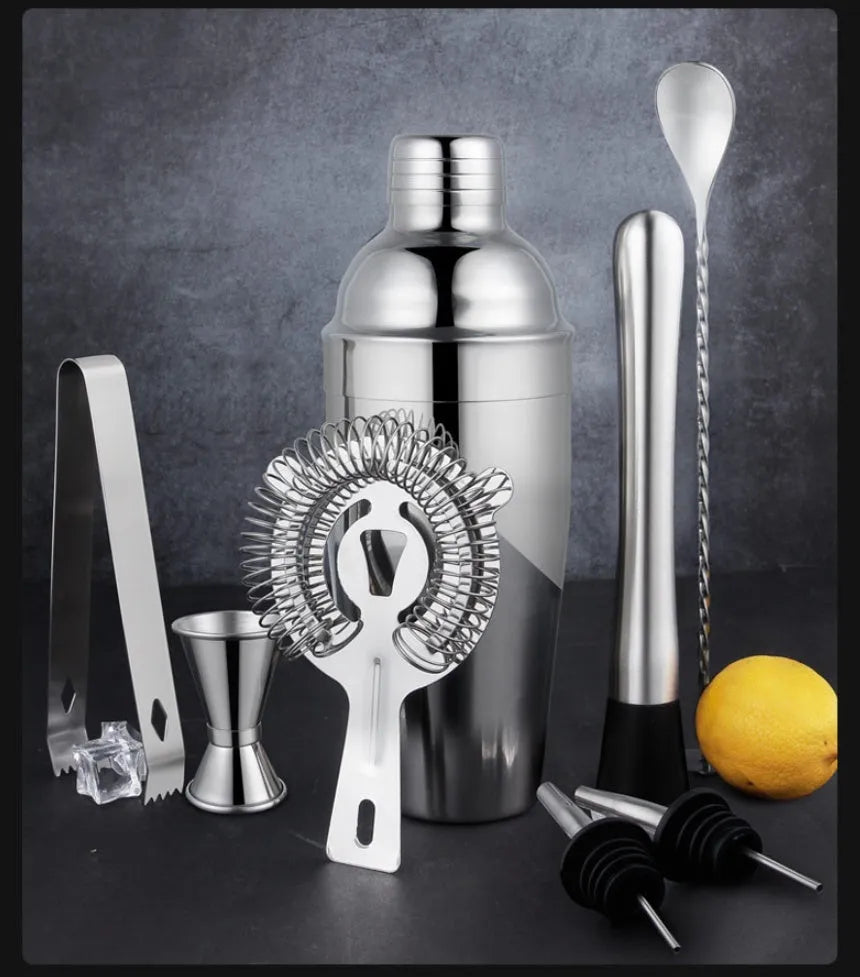 23-piece stainless steel and acrylic European style cocktail mixing set on a bar.