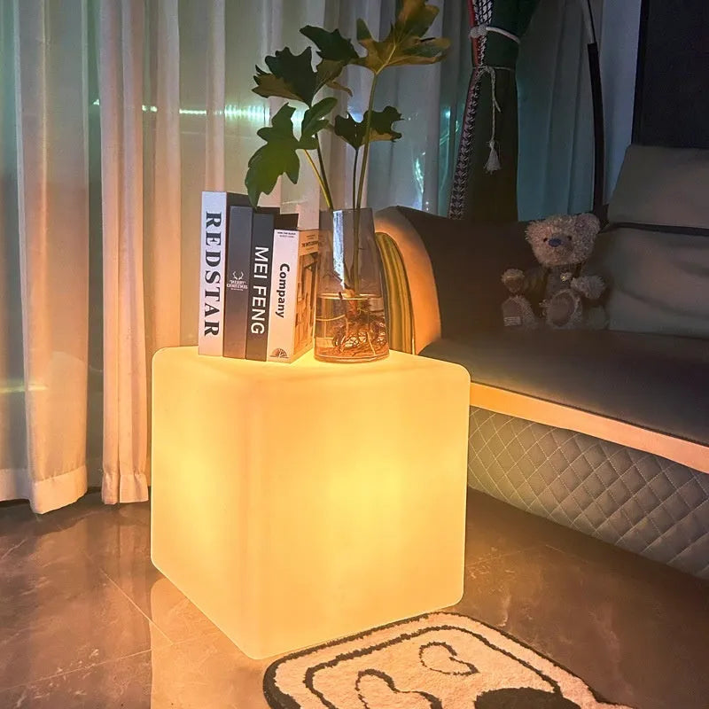 Modern square LED cube light stool in outdoor garden setting showing waterproof IP65 construction