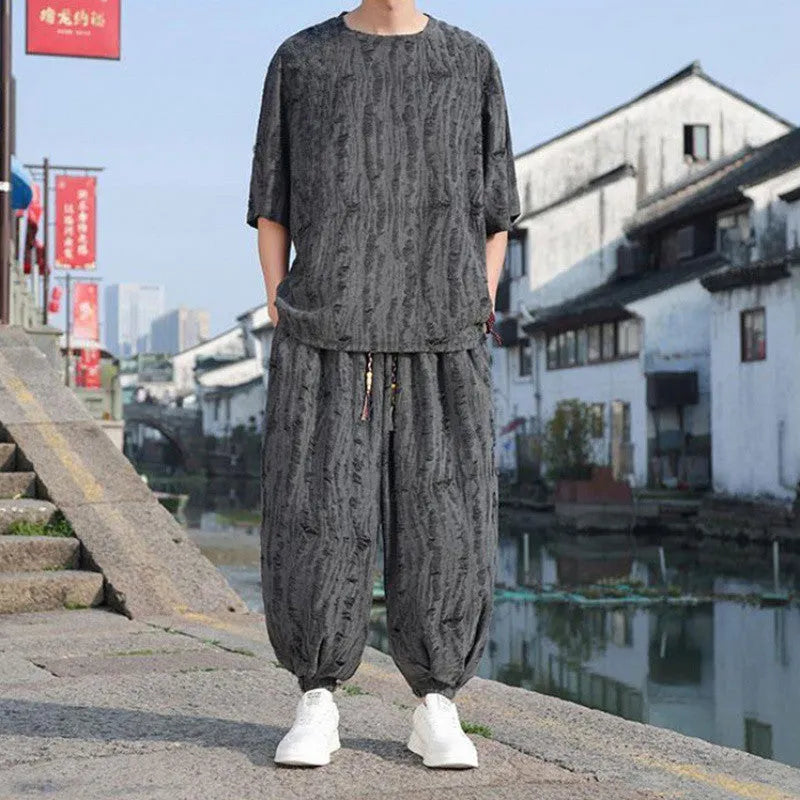 Men's lightweight knitted two-piece suit with short sleeves and cropped trousers in grey.