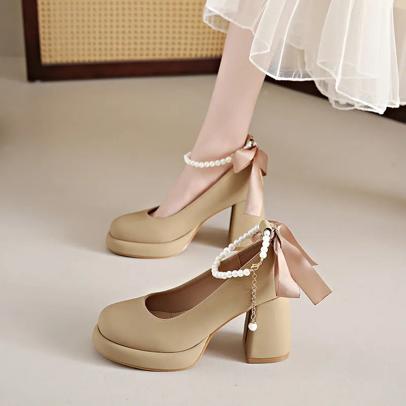 Women's beige Mary Jane shoes with a chunky heel and an adjustable ankle strap buckle.