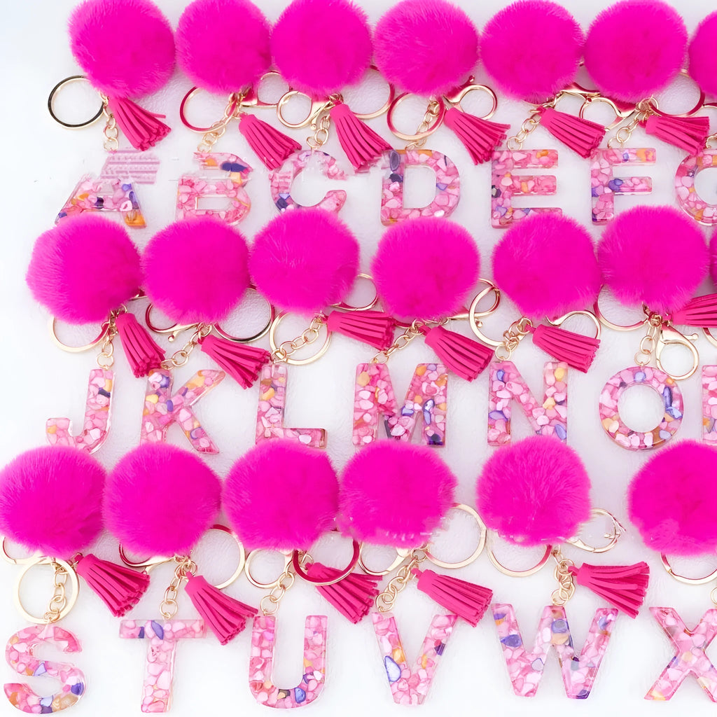 Rose red stone keychain with English letter B, fur ball and tassel on a white background