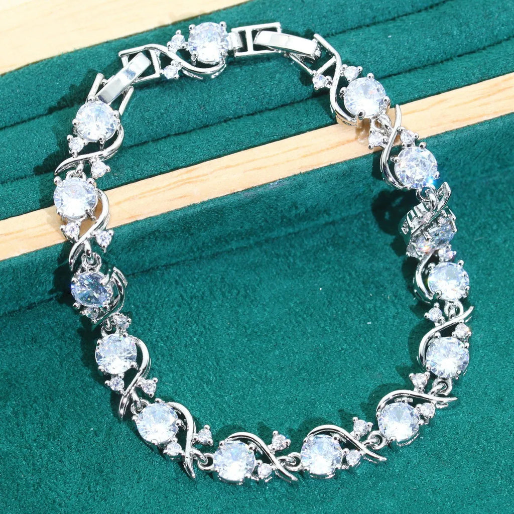 Four-piece bridal zircon jewellery set showing necklace with water wave chain, bracelet, earrings, and ring in alloy with coloured zircon stones