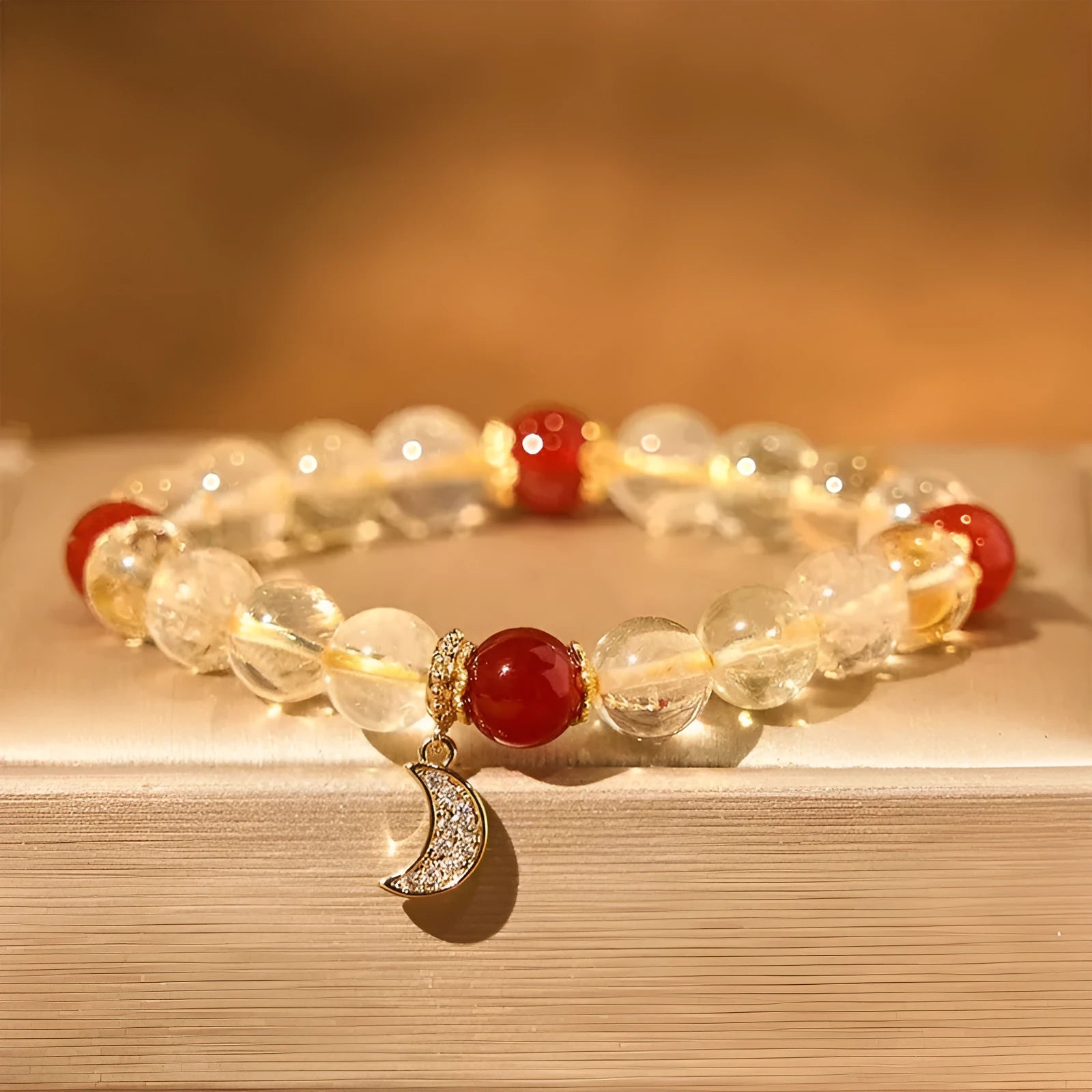 Women's crystal boom bracelet featuring citrine stone, red agate, and central moon design