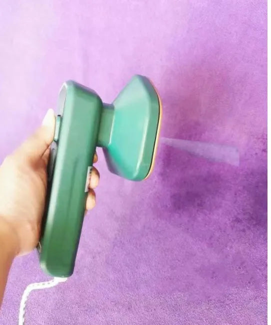 Dark green portable hand-held steam ironing machine with a ceramic panel.