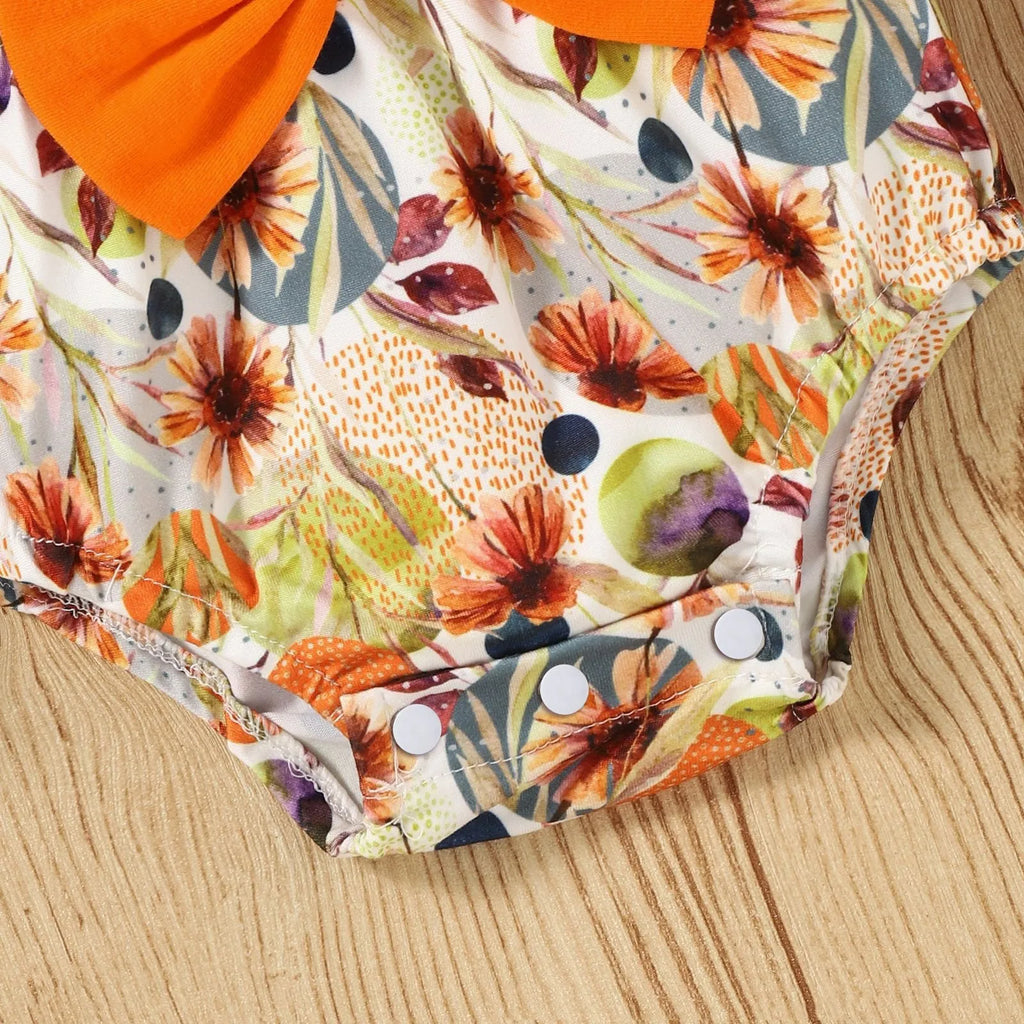 Baby wearing a floral flare sleeve romper band set with matching headband on a neutral background