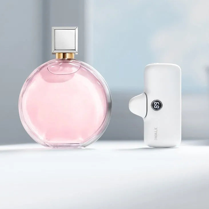 Compact white lipstick-shaped power bank showing screen display next to a smartphone.
