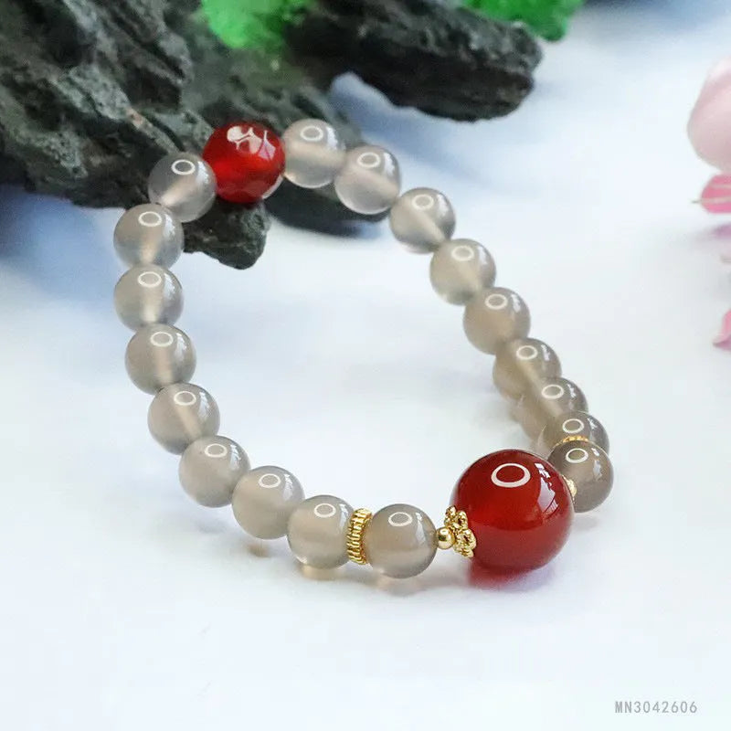 Smoky purple and red agate bracelet with 8mm geometric beads on a wrist.