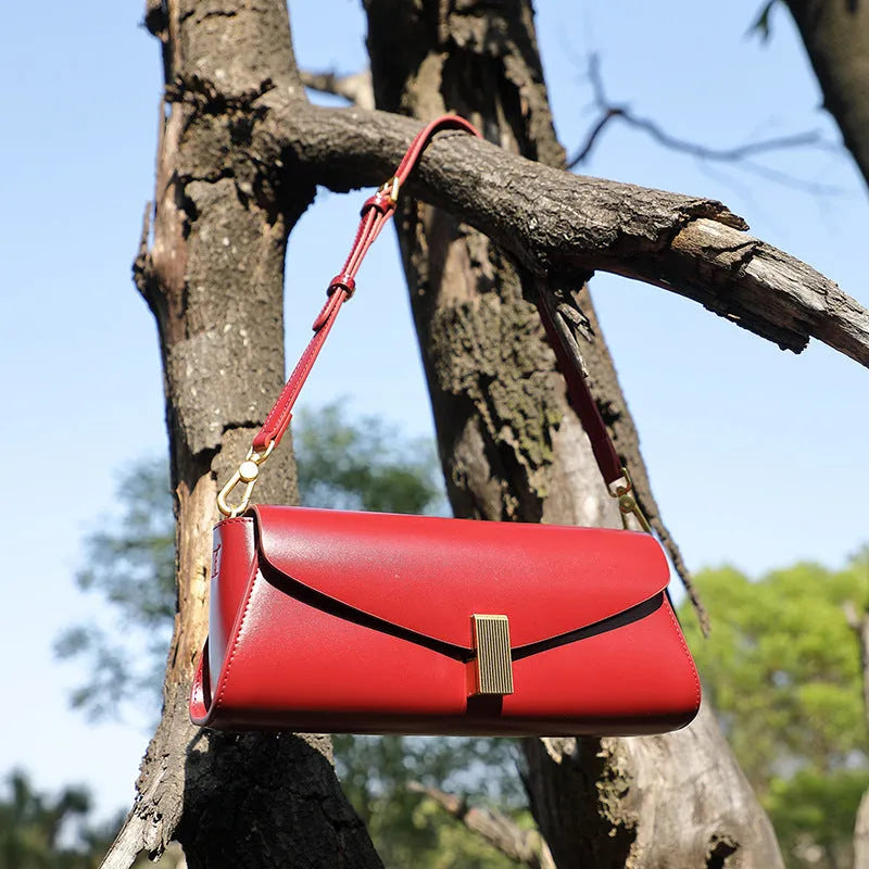 Women's cowhide leather cross-body bag in pillow shape with clamshell opening