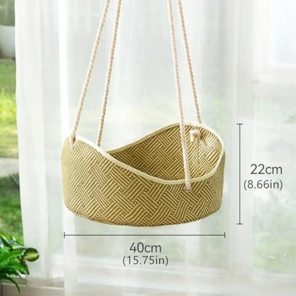 Green rattan cat hammock with metal hooks hanging on a white cage.