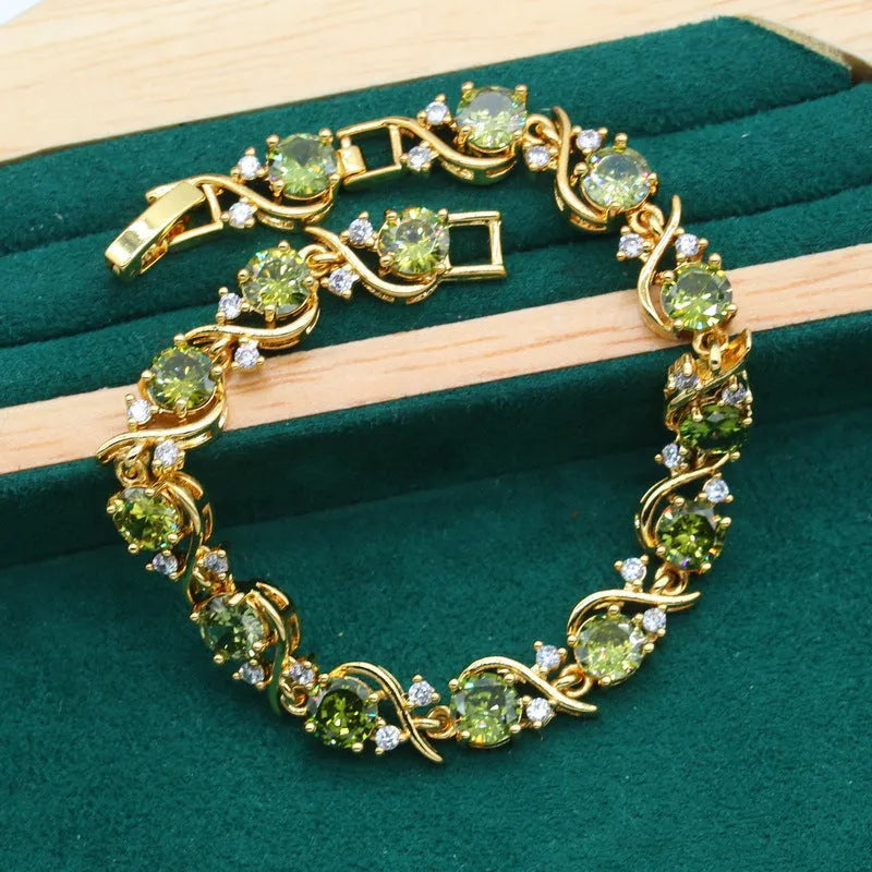 Olive green and red zircon jewellery set for women featuring a necklace with snake bone chain, matching earrings, and a ring.