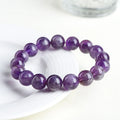 Natural purple feather amethyst crystal bracelet with geometric Ruyi design and scattered beads.