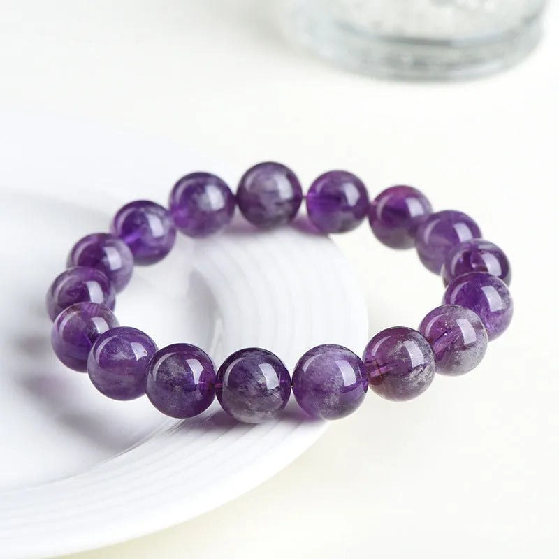 Natural purple feather amethyst crystal bracelet with geometric Ruyi design and scattered beads.