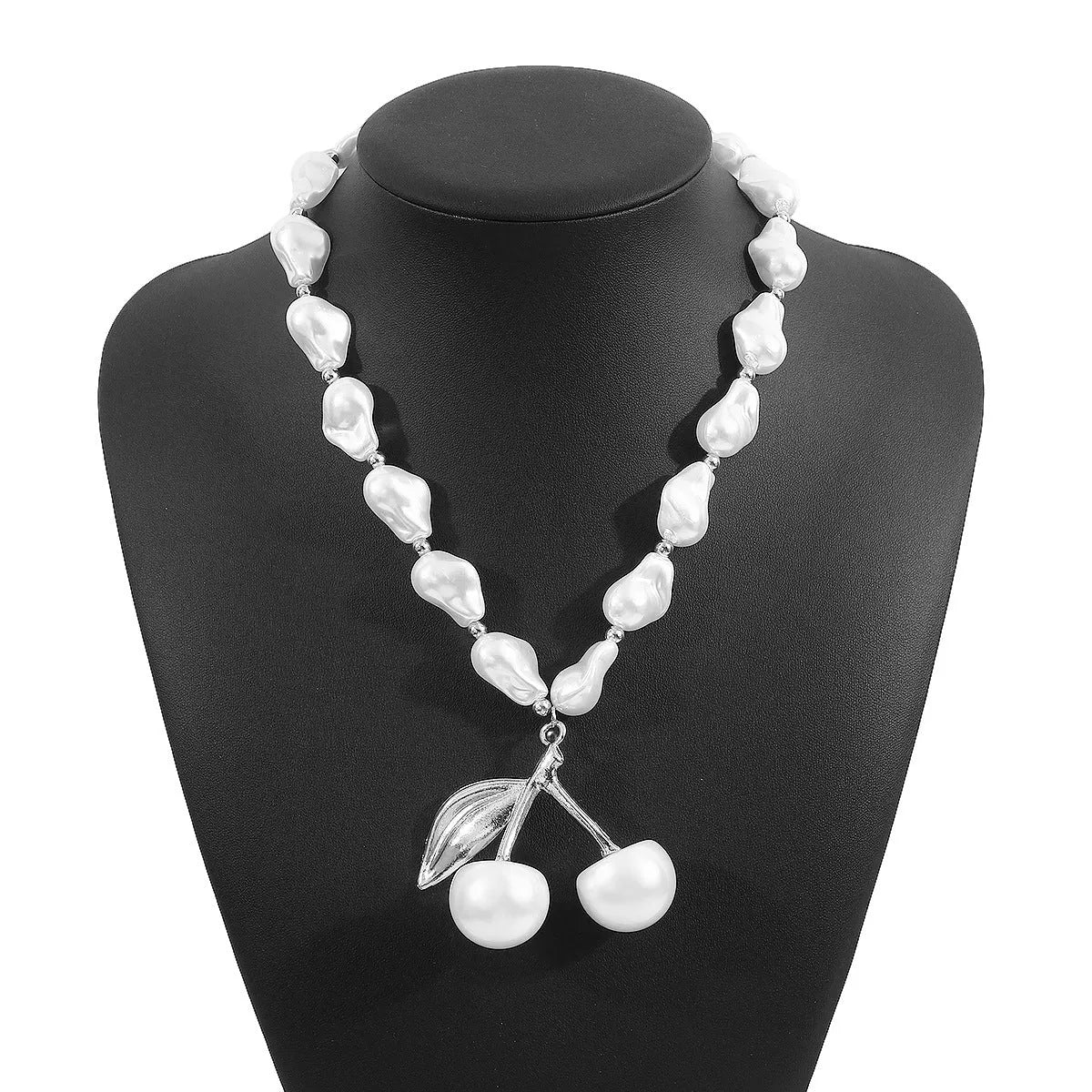 Gold geometric cherry fruit pendant on an adjustable white imitation pearl chain necklace.