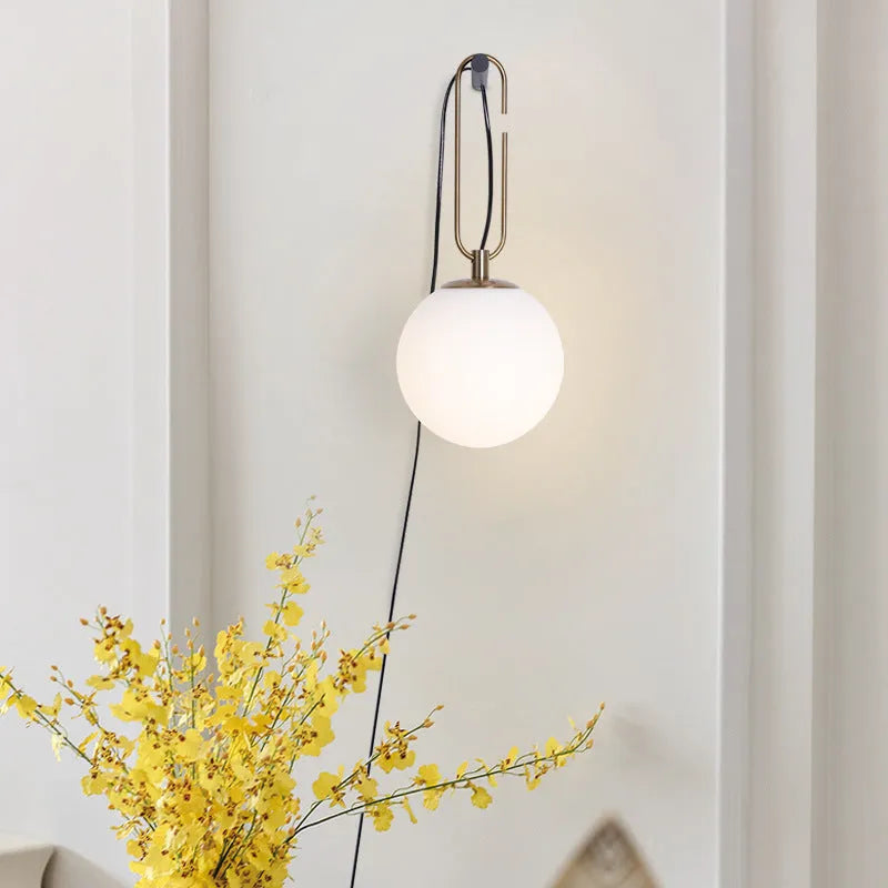 Modern clear glass wall lamp with European design showing three light colour options.