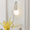 Modern clear glass wall lamp with European design showing three light colour options.