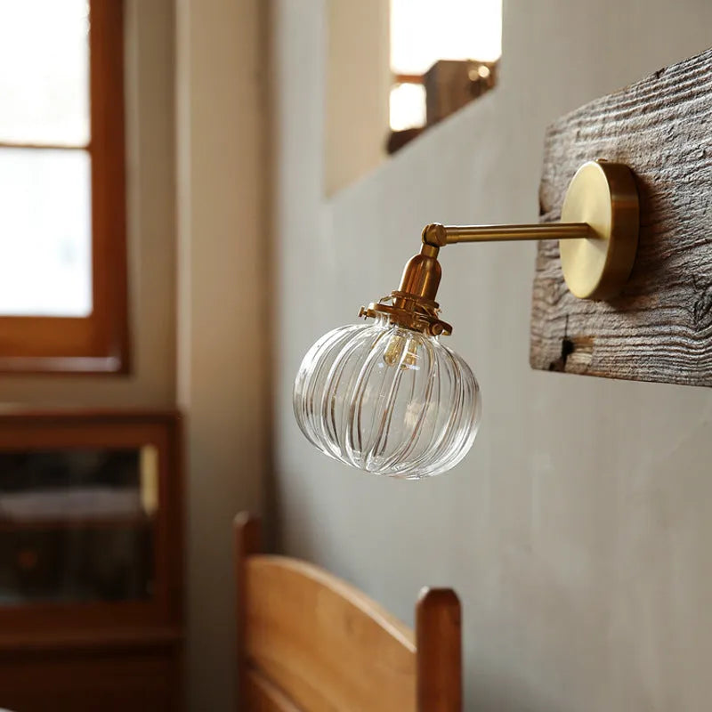 Pumpkin-shaped transparent glass wall lamp for living room or bedroom.