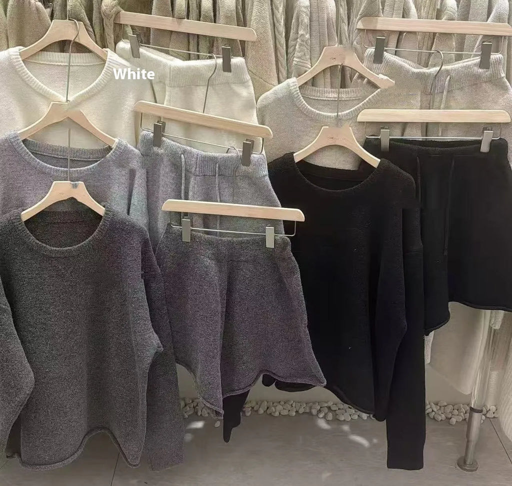 A woman's loose-fitting long sleeve knit sweater and matching wide-leg shorts set in a neutral colour.