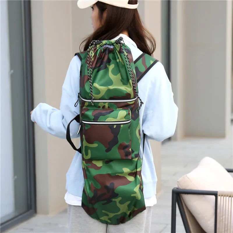 Nylon skateboard backpack in black, shown with a longboard, featuring multiple pockets and adjustable straps.
