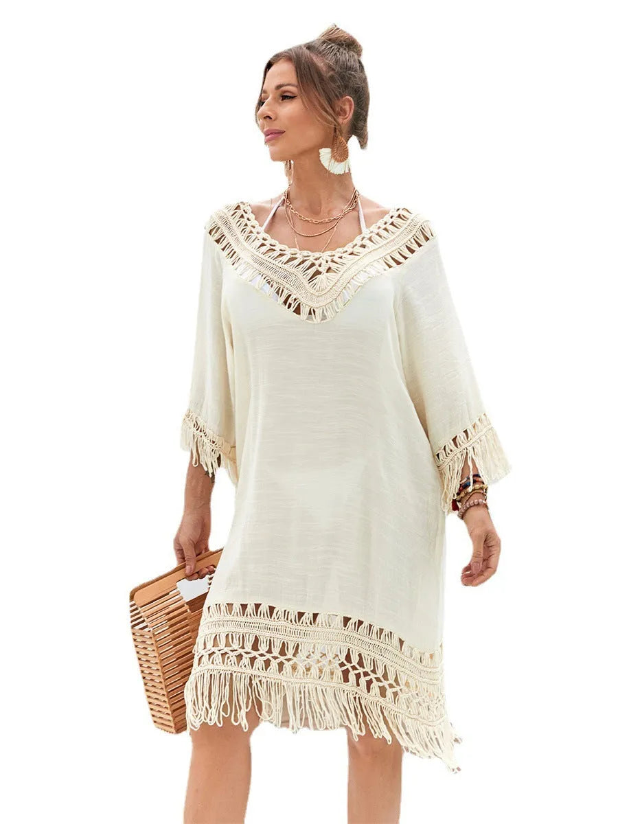 Apricot coloured hand-crocheted long beach dress for women on a hanger.